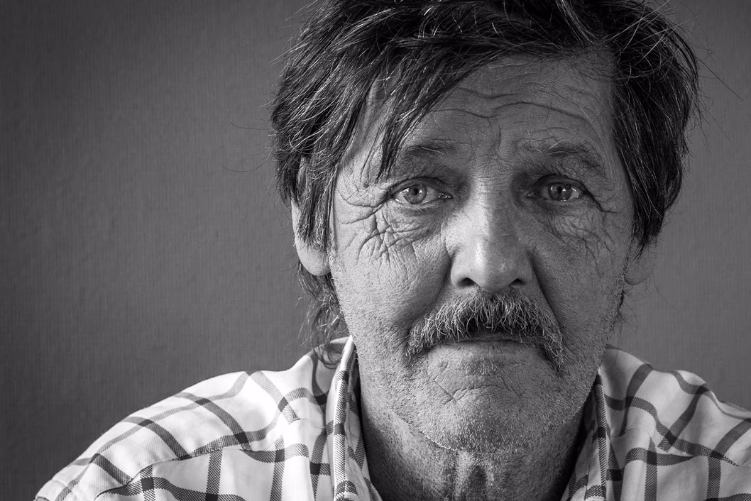 Photo of a man with a check shirt and moustache