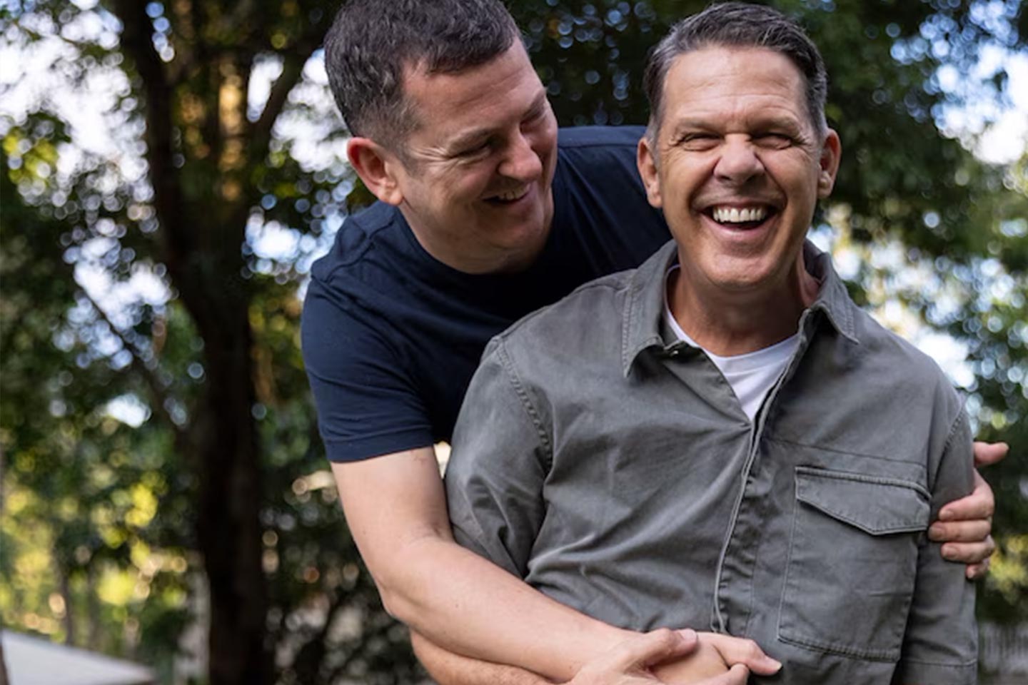 Photo of two men laughing and embracing
