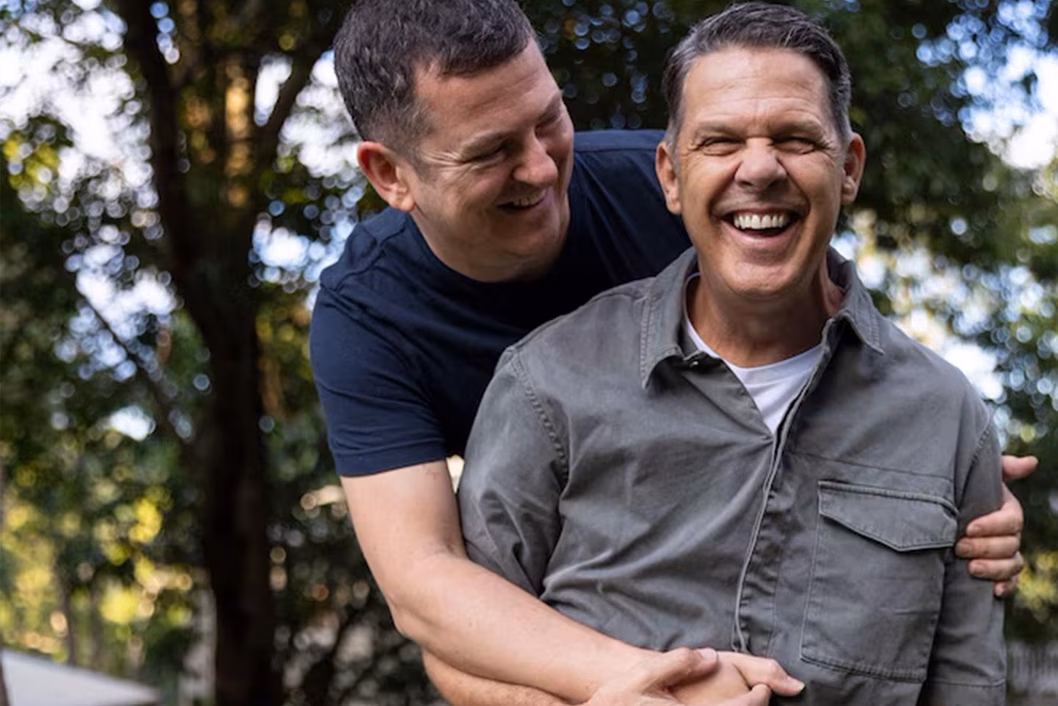 Photo of two men laughing and embracing