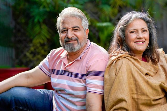 Husband and wide sitting outside back to back