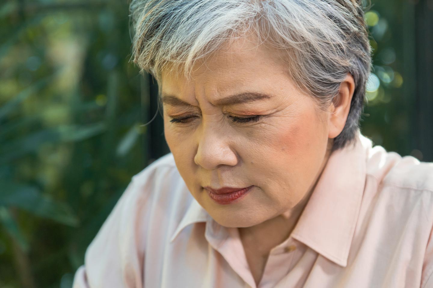 Photo of woman with grey hair and a soft pink shirt