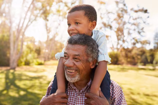 a grandfather with his grandchild on his shoulders
