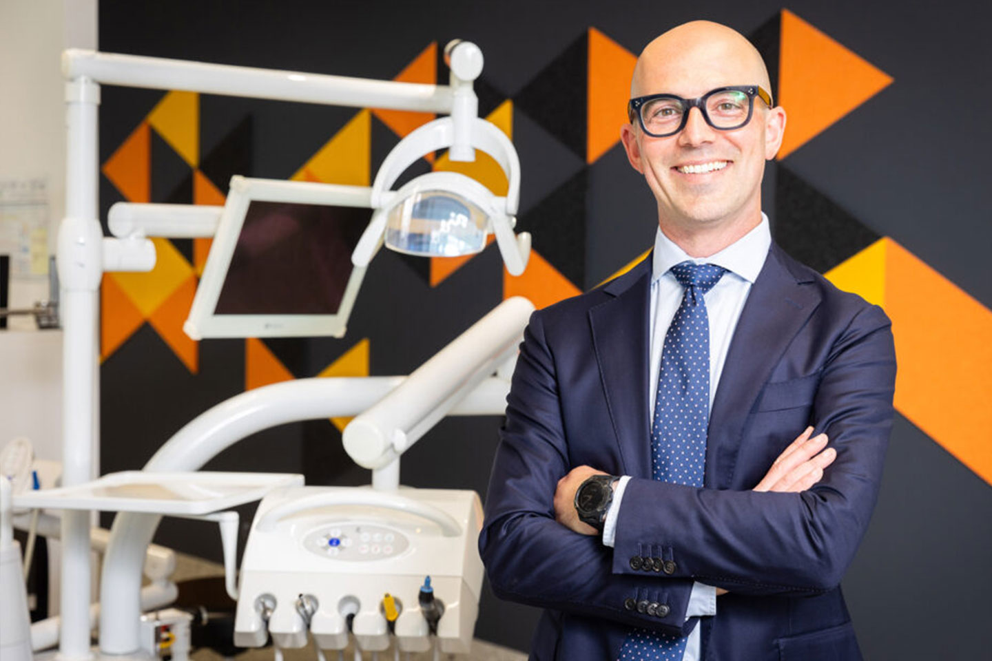 Photo of a man smiling next to dentist equipment