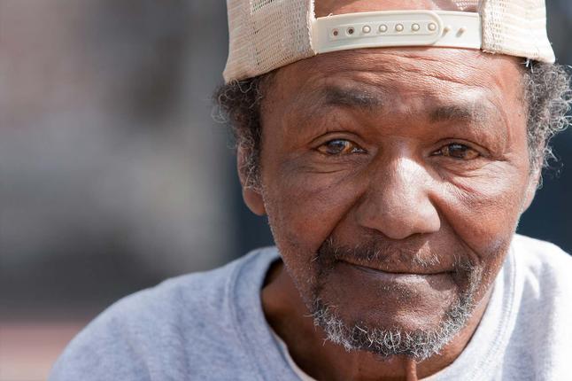 Photo of a man wearing a cream cap backwards