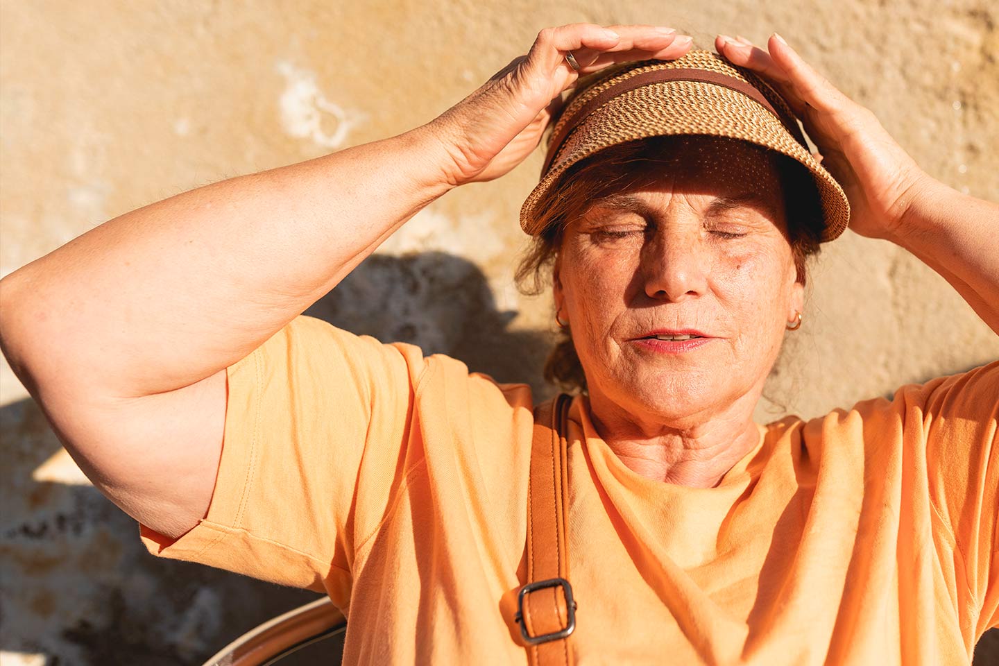Photo of a woman in the sunshine wearing a hat