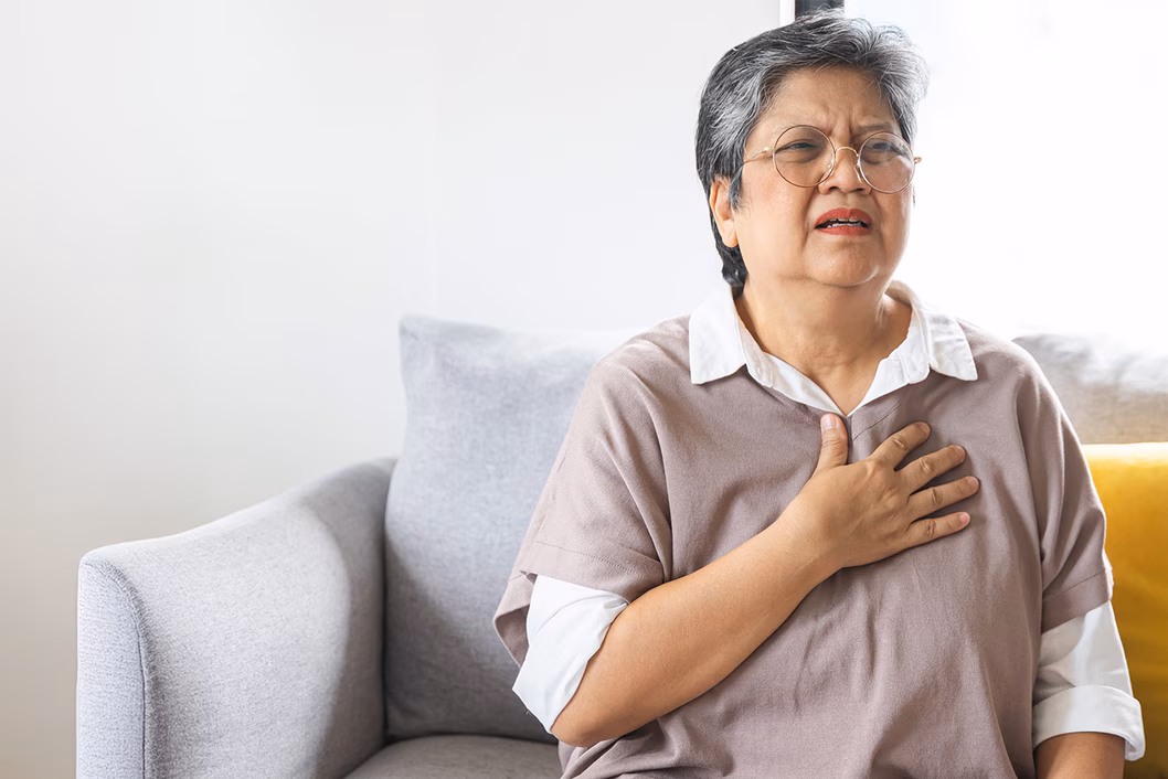 Photo of a woman in a mauve top looking anguished