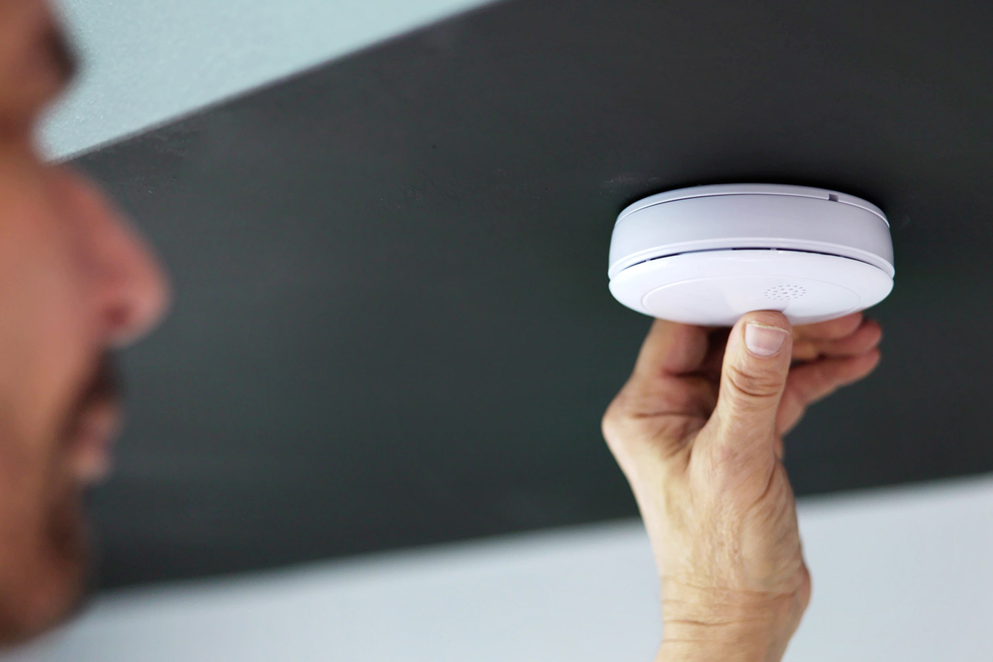 Photo of man installing a smoke alarm