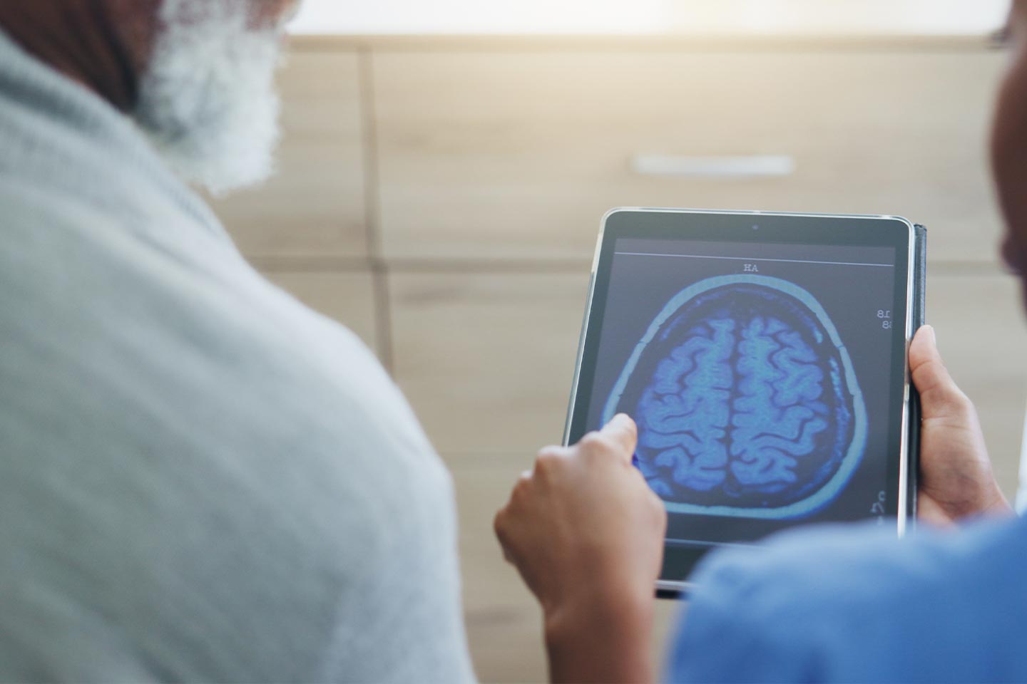 Photo of health worker reviewing brain scan on a tablet