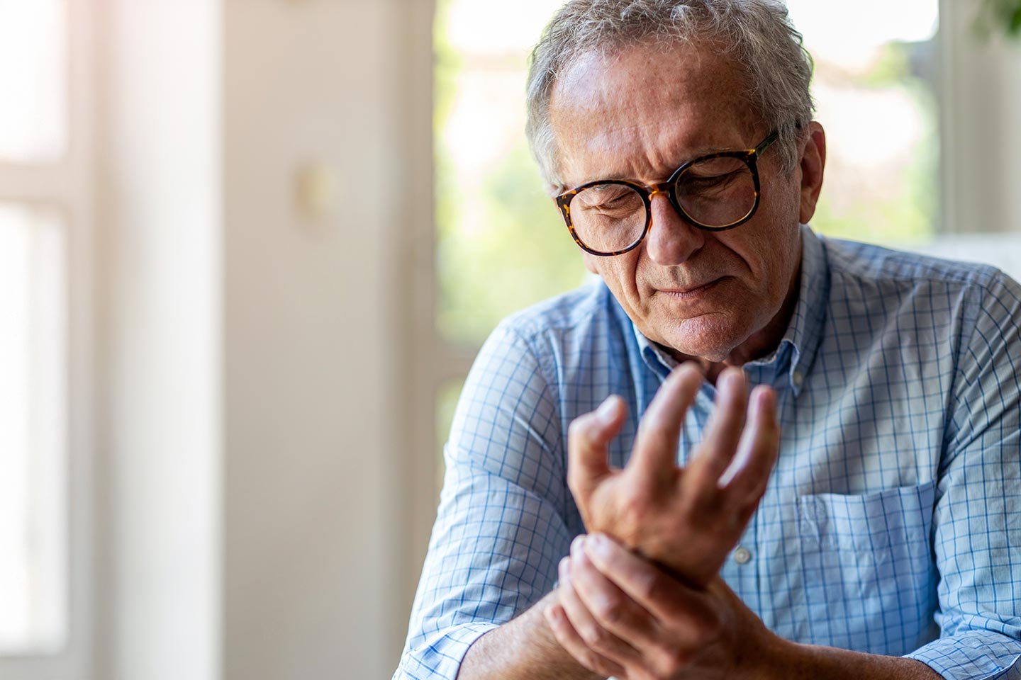 Photo of a man holding his wrist