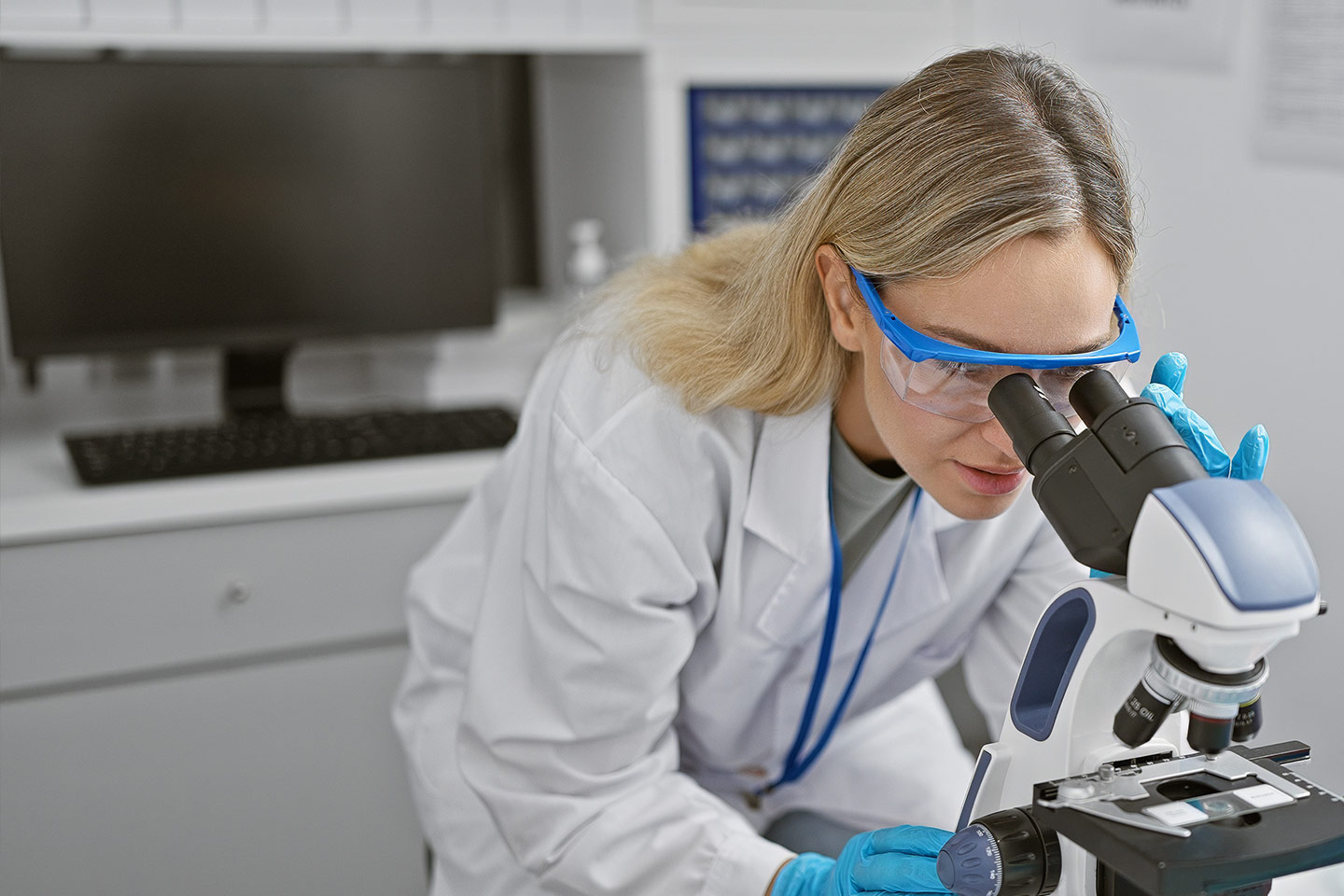 Photo of a scientist peering into a microscope