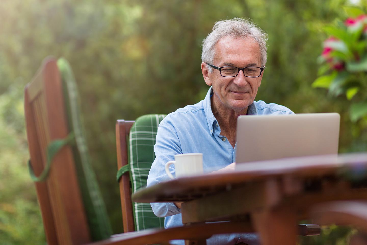 Photo of a man sitting in a garden with a computer