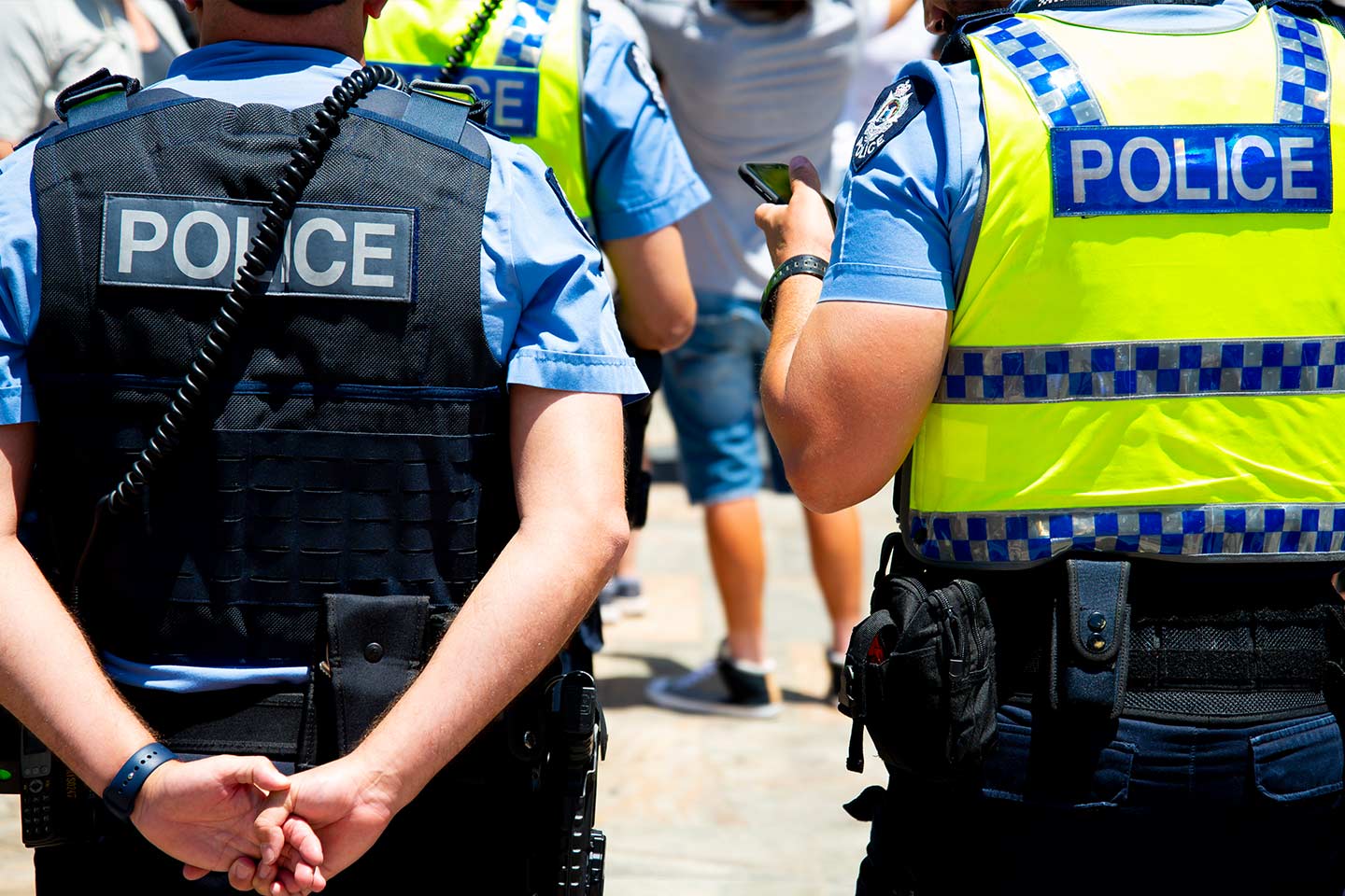 Photo of police wearing vests standing outside