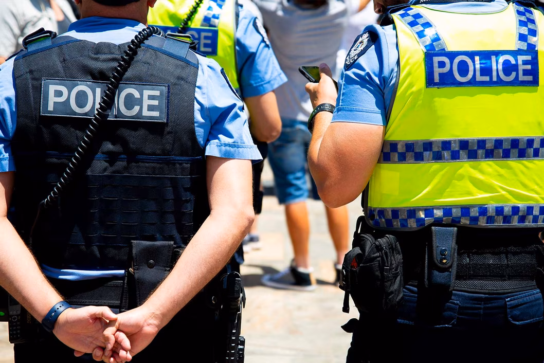 Photo of police wearing vests standing outside