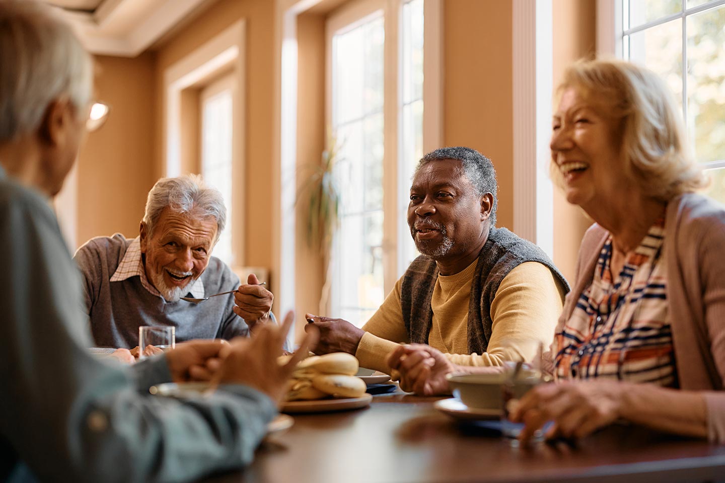 A group of people eating together and laughing