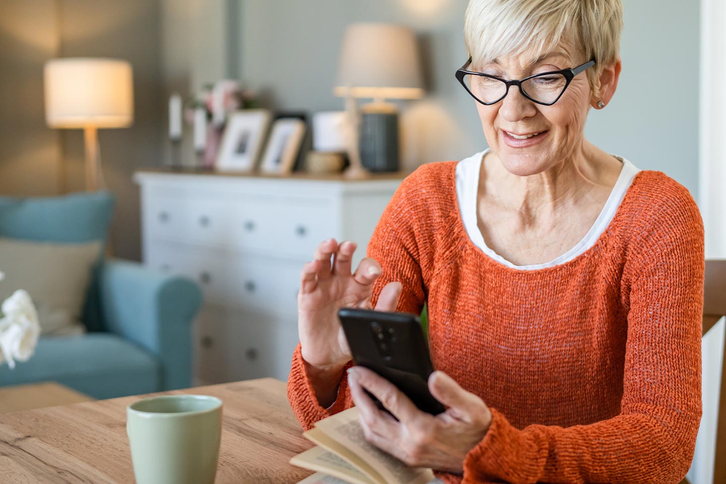 Photo of a woman in an orange jumper using her mobile phone