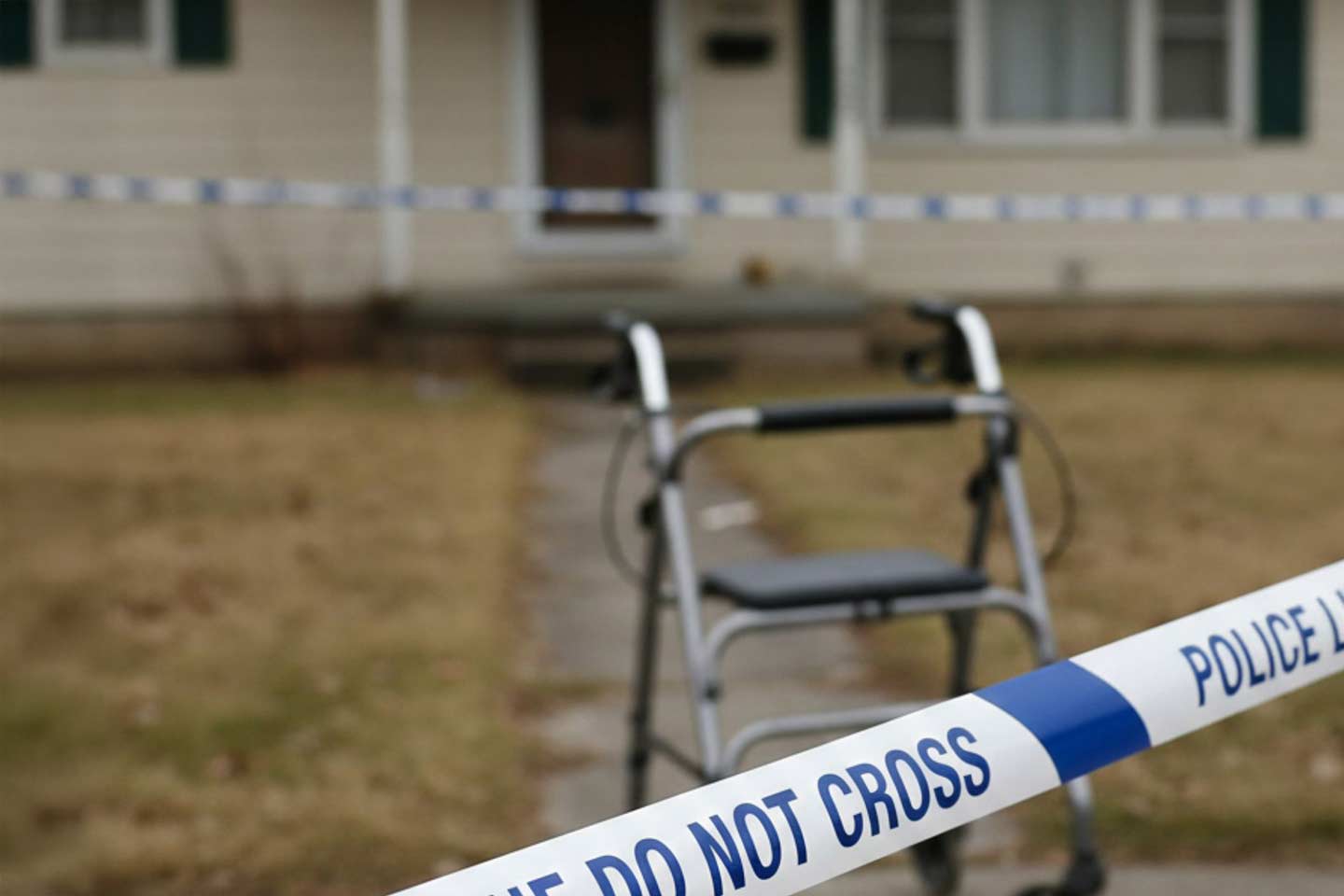 Photo of police crime tape with a walker in the background