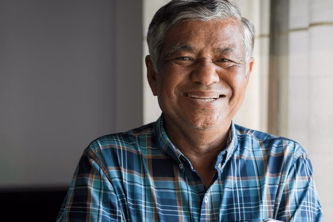 Photo of a laughing man in a blue plaid shirt