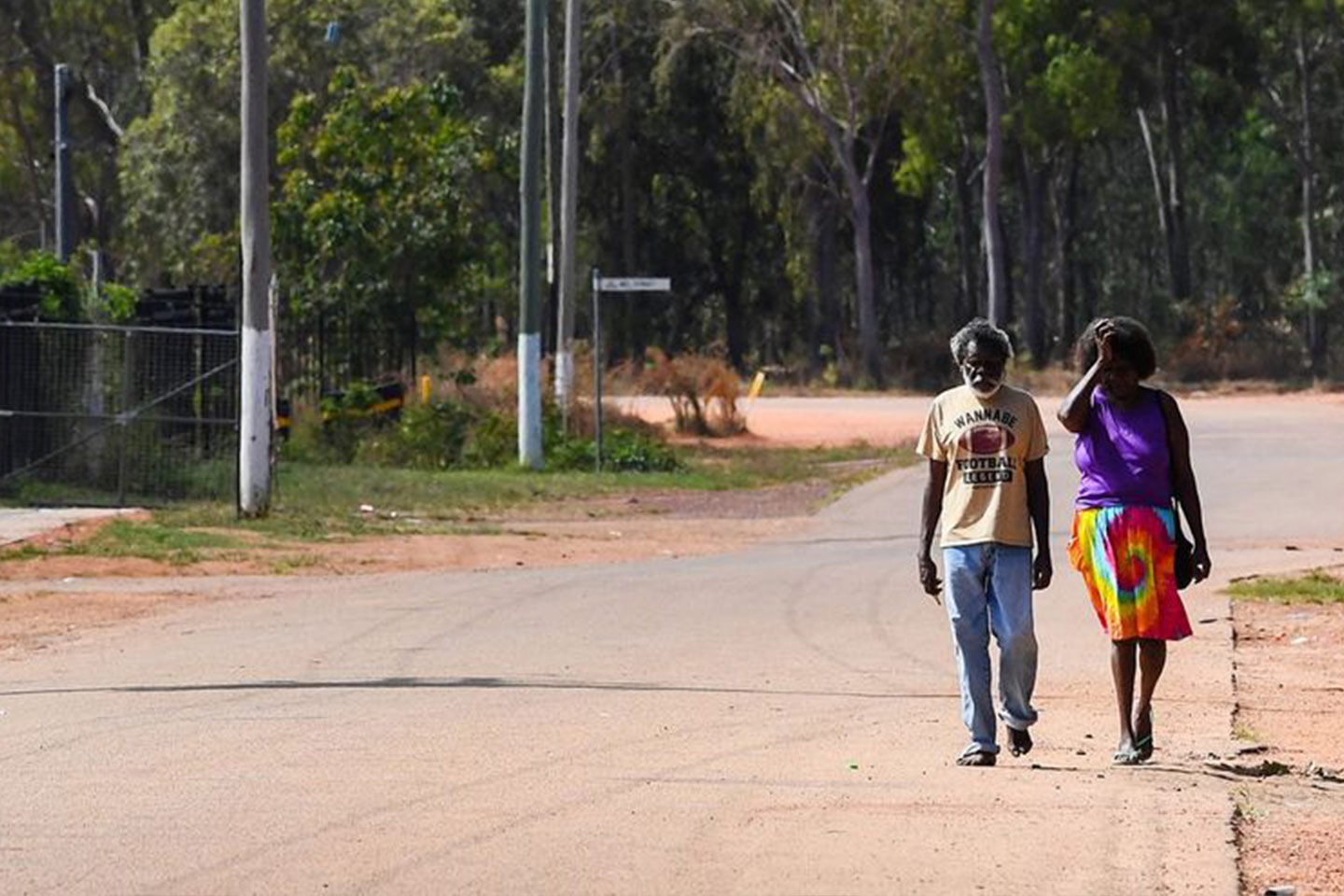 Photo of two people walking along a rural road