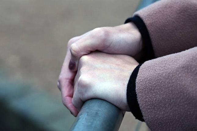 Photo of hands holding a metal hand rail