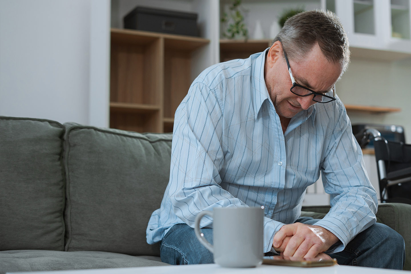 Photo of a man in a blue striped shirt sitting at a coffee table