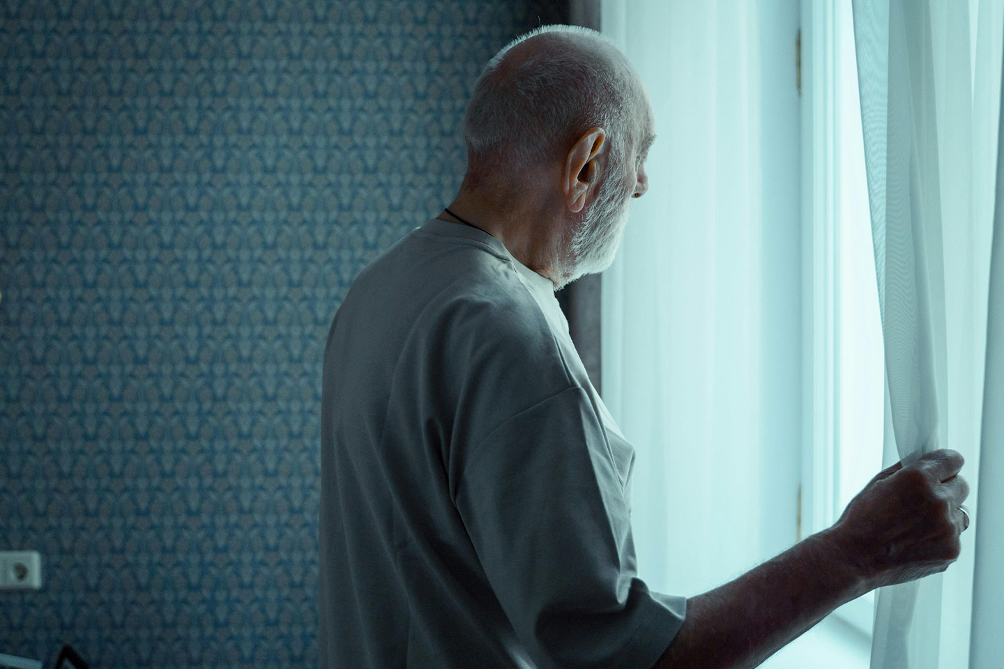 Photo of a man staring out of a window