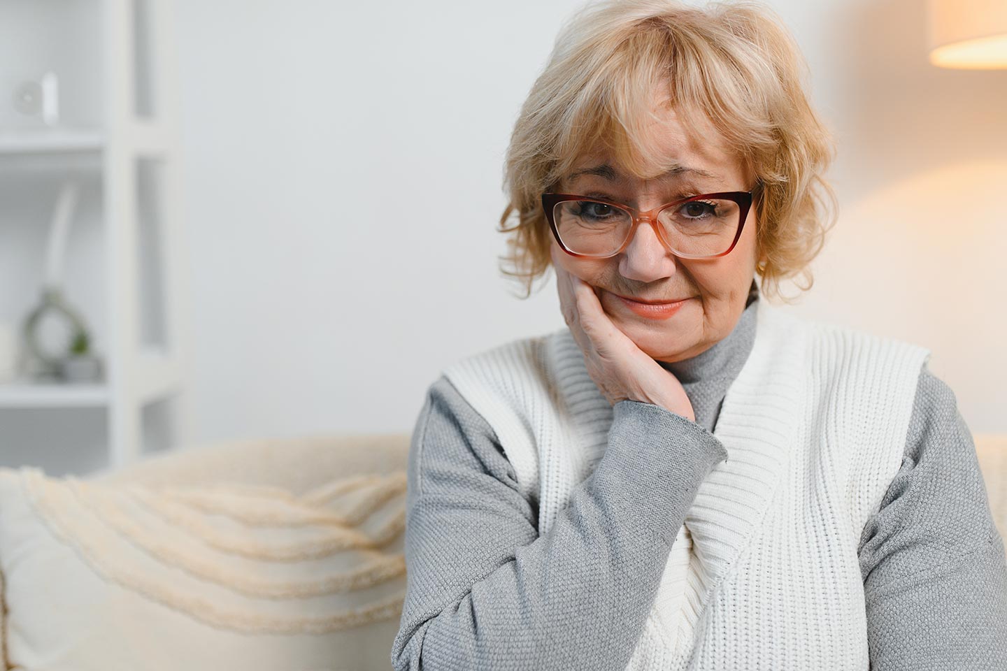 Photo of a woman in a grey on grey outfit in a pale loungeroom