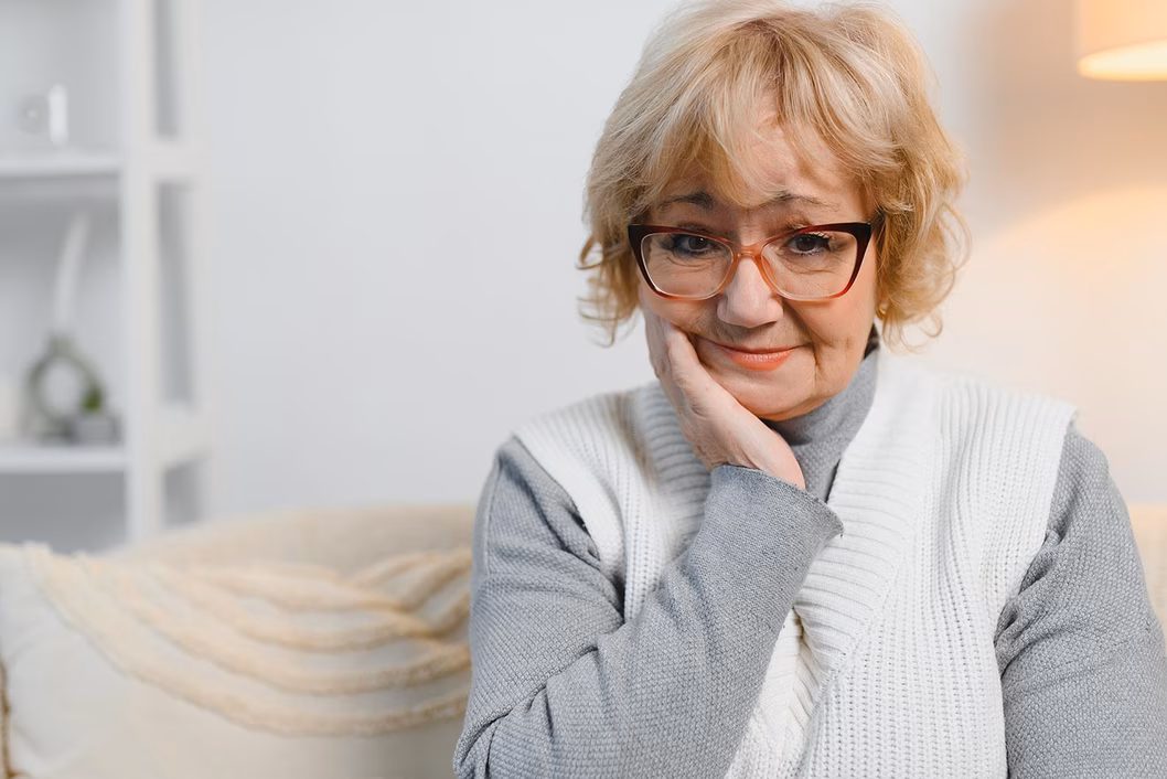Photo of a woman in a grey on grey outfit in a pale loungeroom