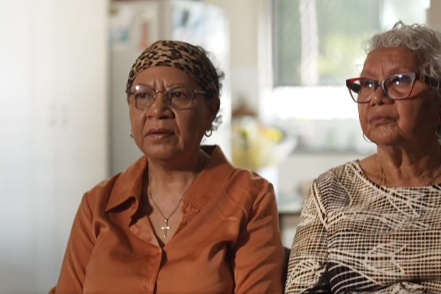 Photo of two women wearing earth tone blouses