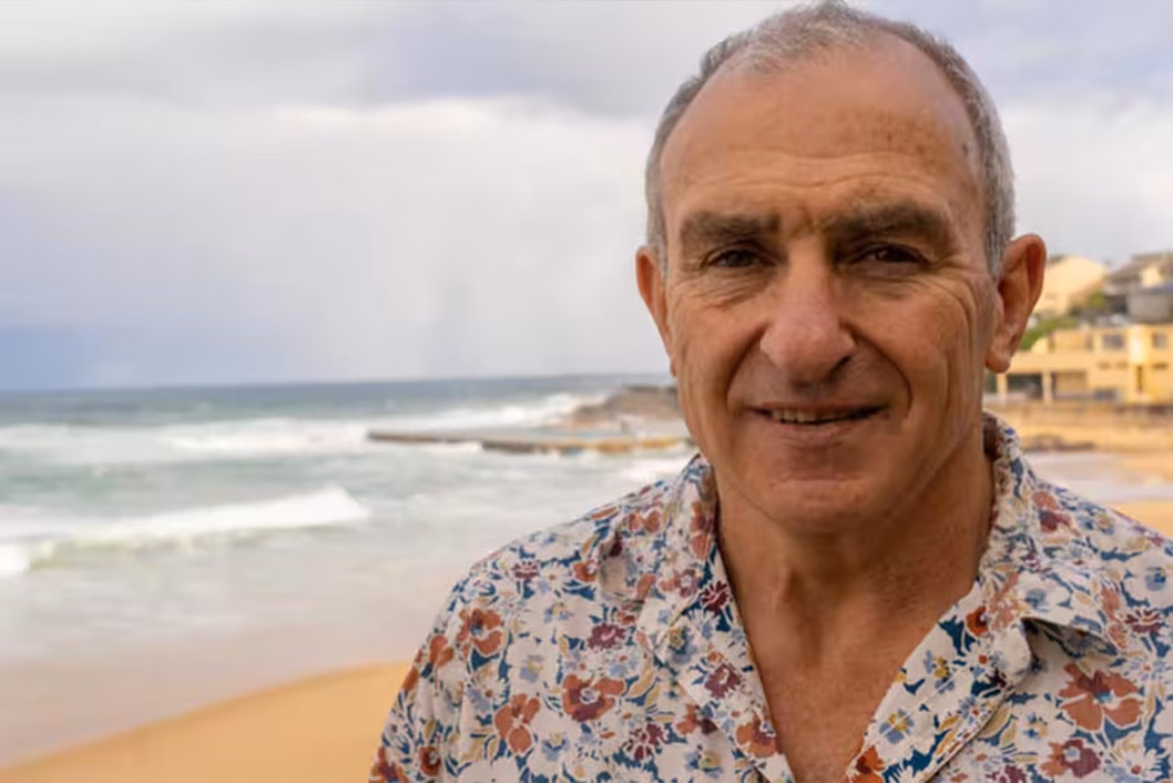 Foto eines Mannes in einem geblümten Hemd am Strand