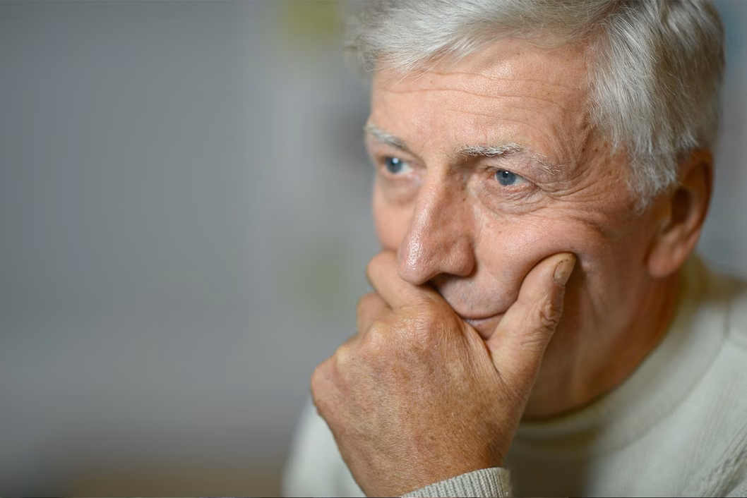 Photo of a man holding his chin in his hand