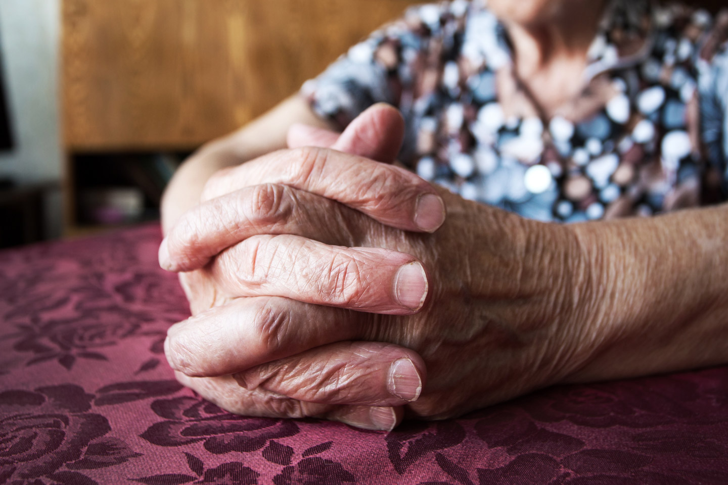 Close up picture of older woman's hands on a table