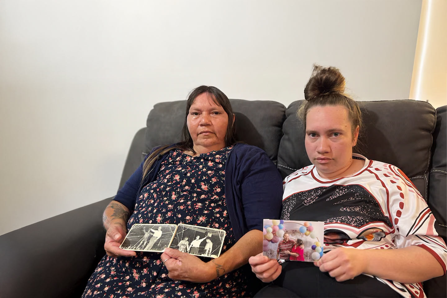 Photo of two women holding photographs