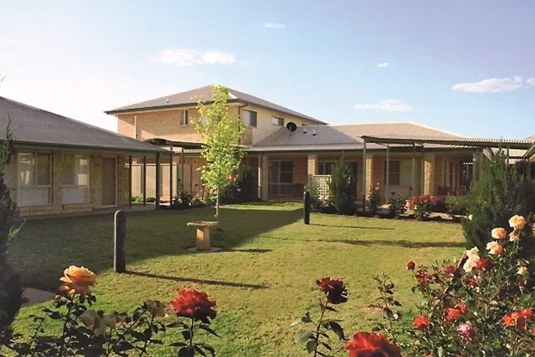 Photo of a group of buildings surrounding a rose garden