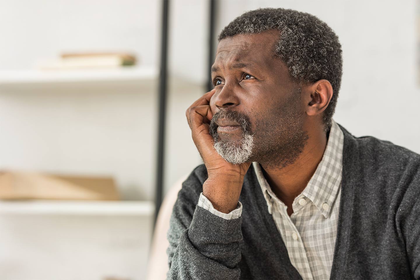 Photo of a pensive man resting his chin on his hand