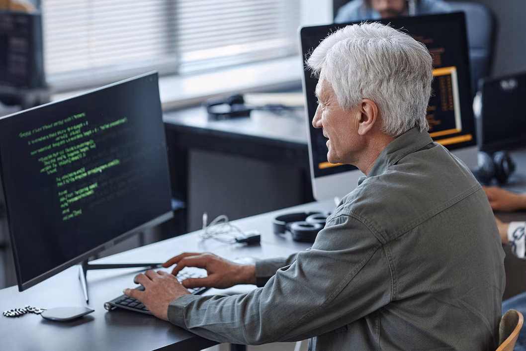 Photo of older man at computer desk