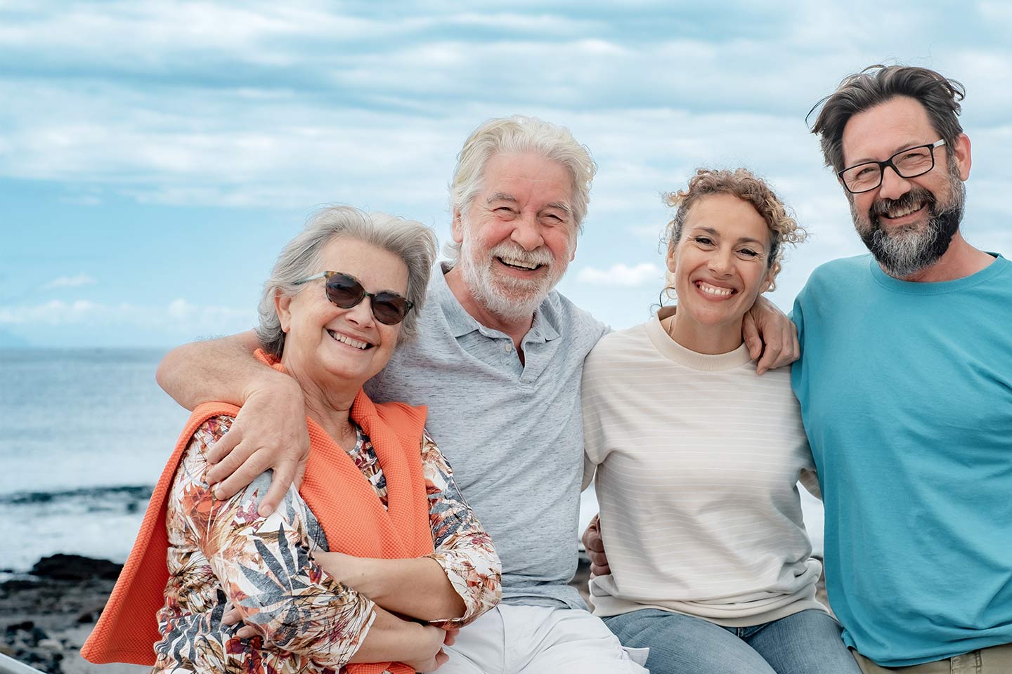 Photo of a group of four smiling people on a beach