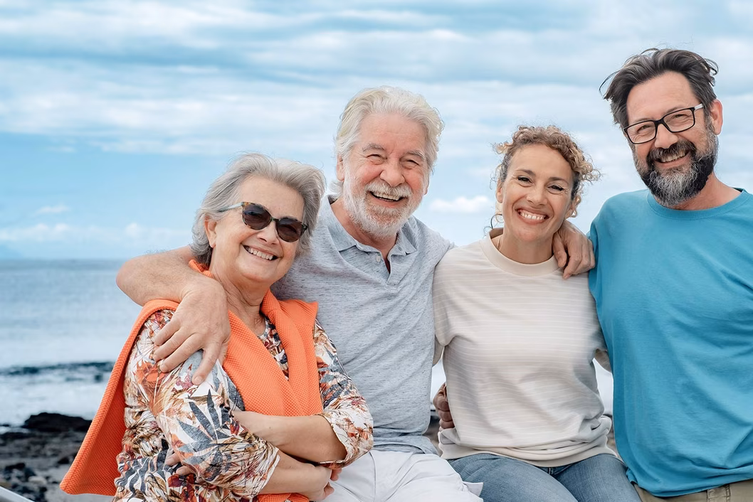 Photo of a group of four smiling people on a beach