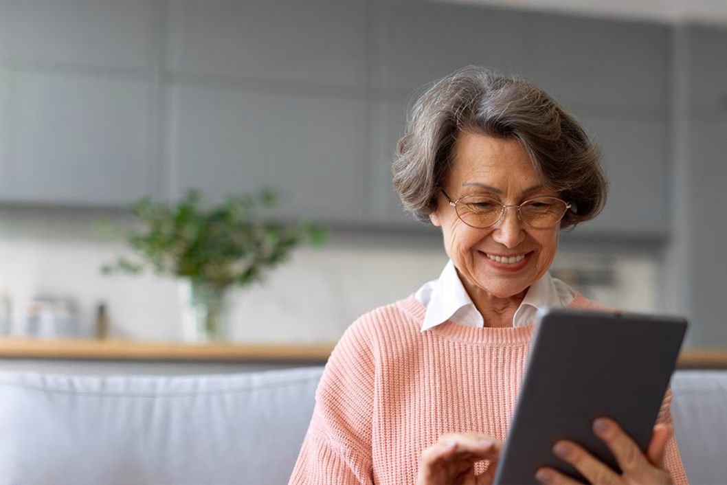 Image of an older woman looking at a tablet