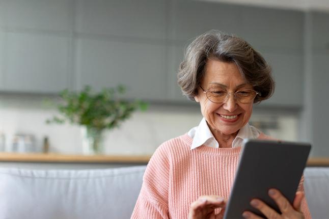 Image of an older woman looking at a tablet
