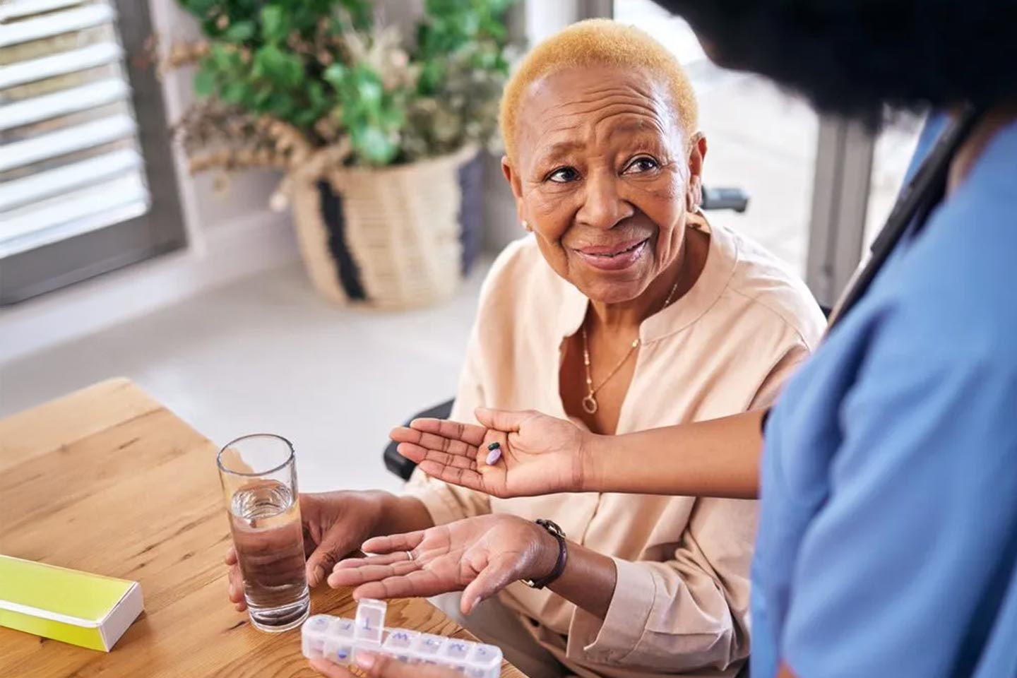 Photo of a woman accepting pills from a health worker