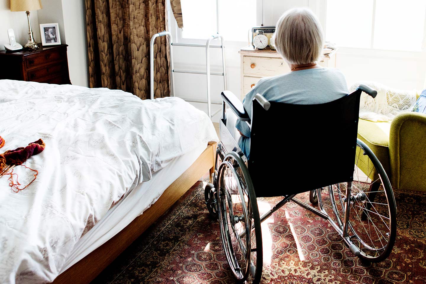 Photo of a woman in a wheelchair in a sunny room