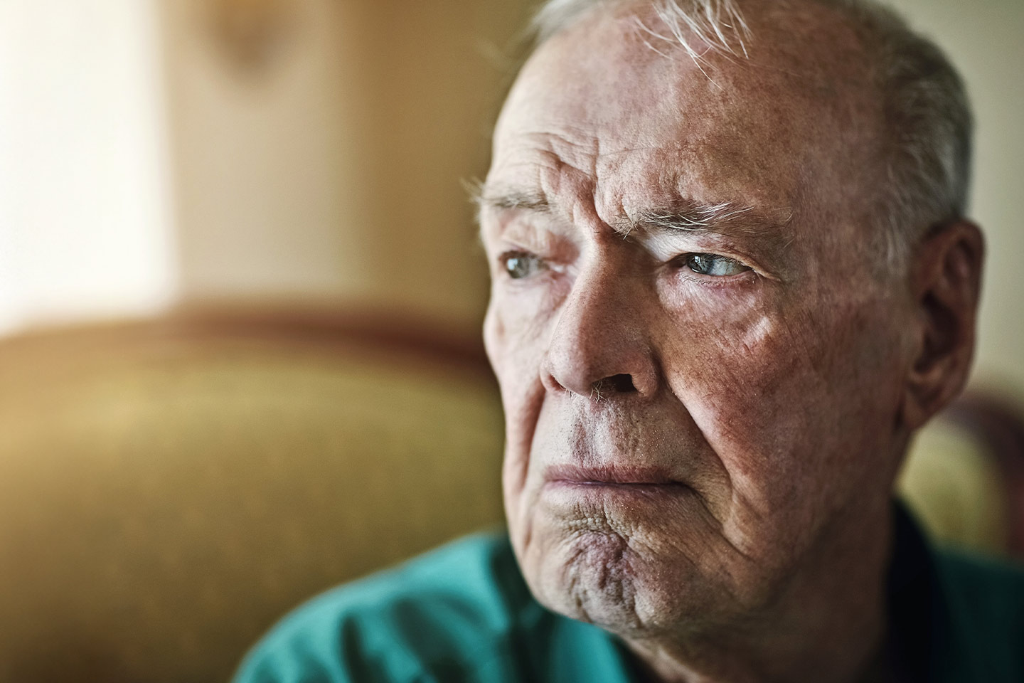 Photo of a man in a green shirt looking sad