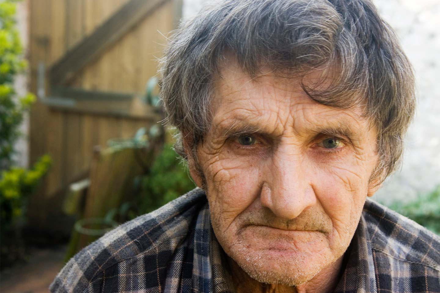 Photo of a man wearing a grey plaid shirt
