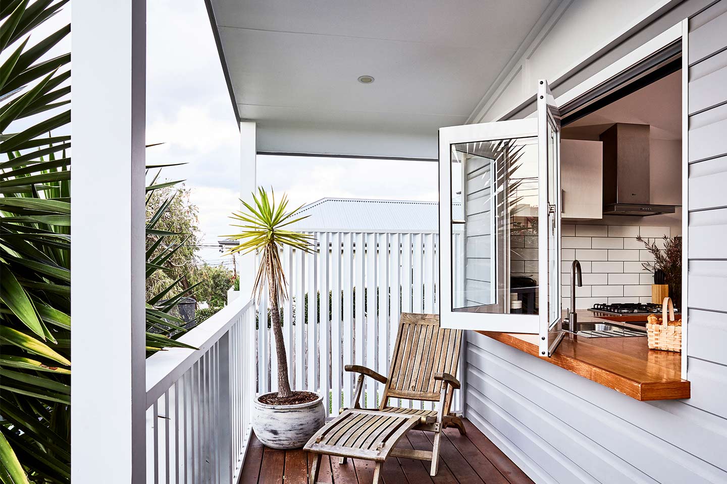 Image of a granny flat with a verandah and bi-fold windows opening onto a kitchen