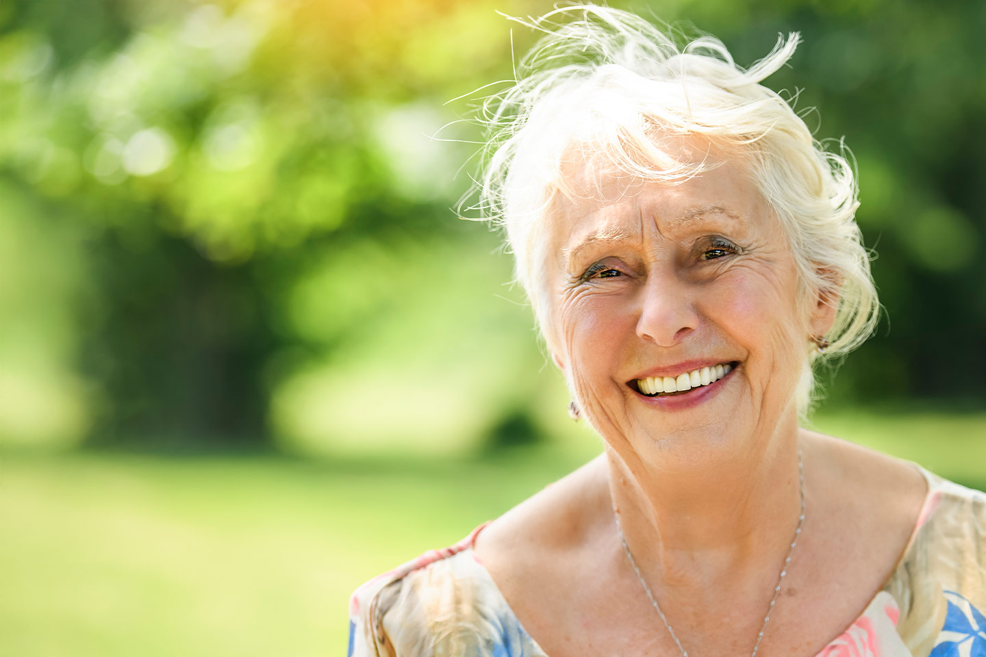 Photo of a woman smiling outdoors in the sun