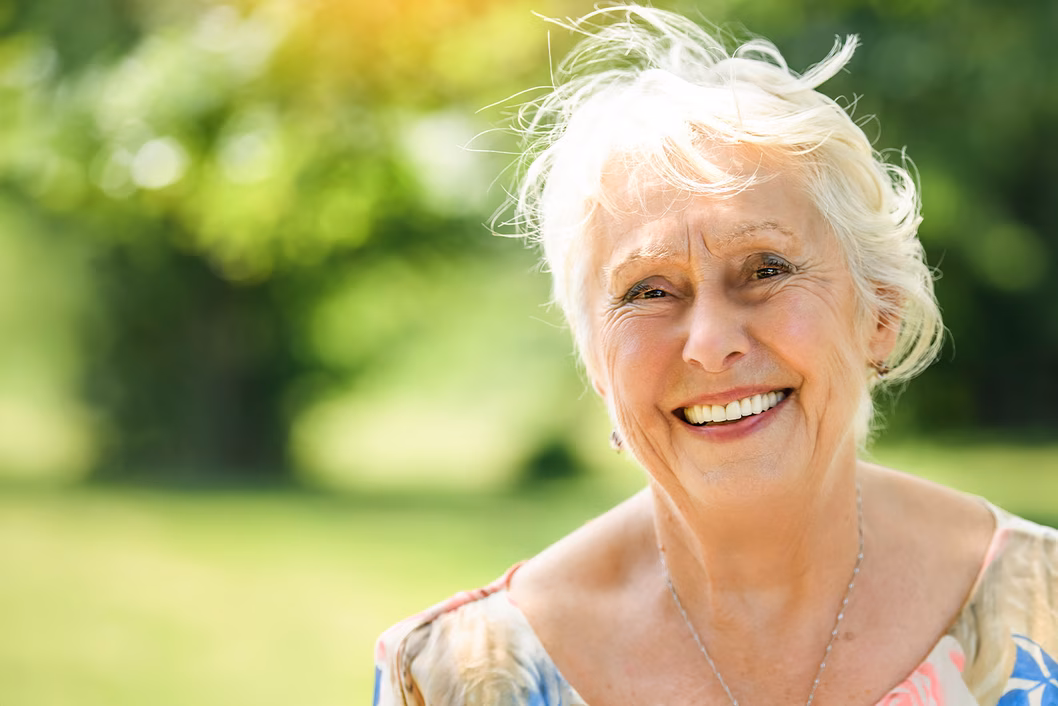 Photo of a woman smiling outdoors in the sun