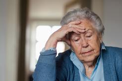 Image of an older woman contemplating a tough decision