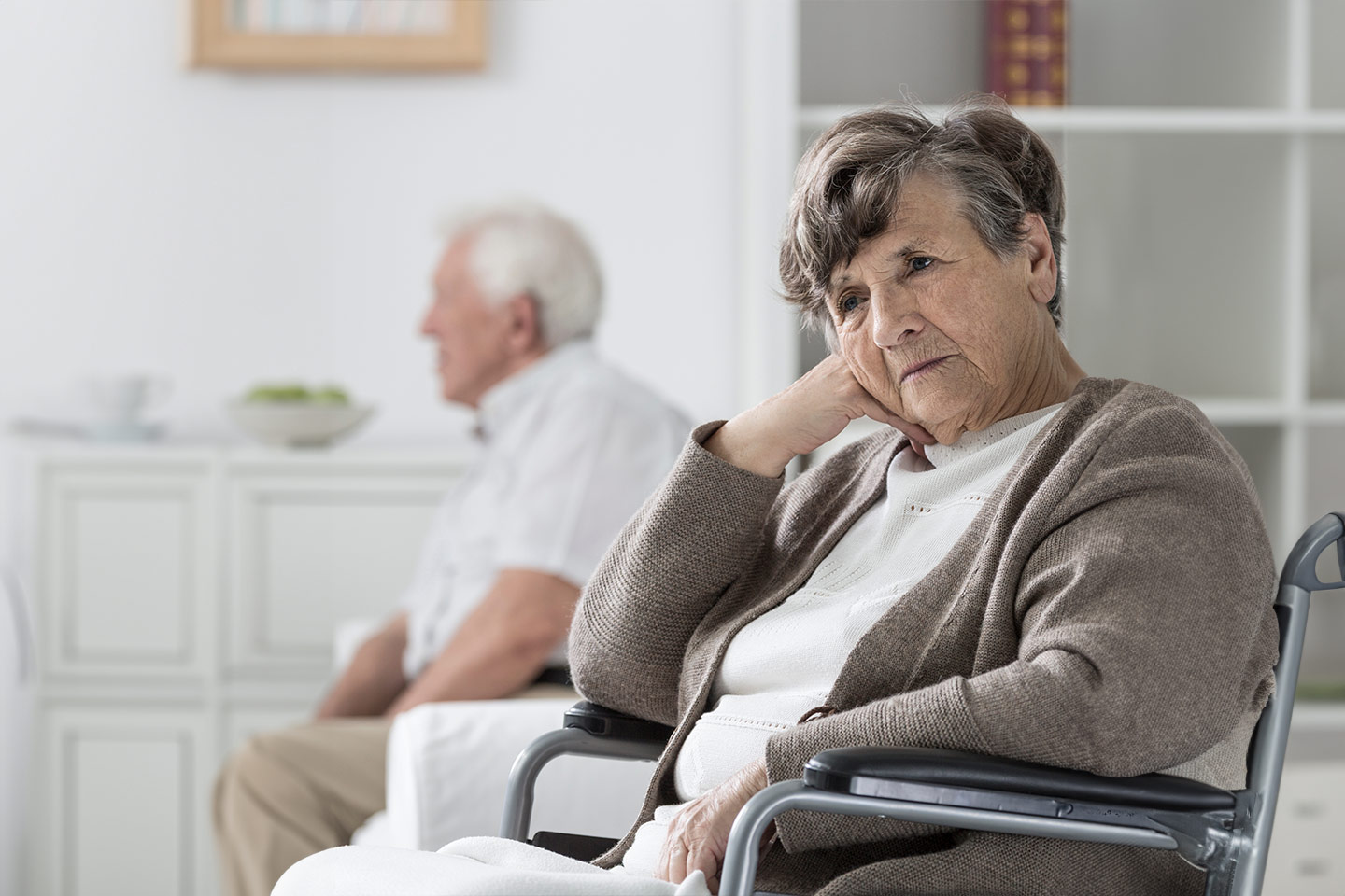 Photo of a woman wearing a taupe cardigan in a wheelchair