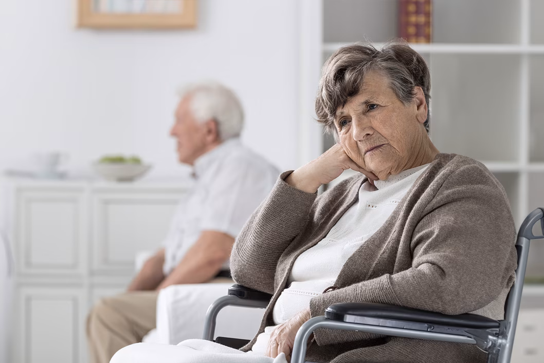 Photo of a woman wearing a taupe cardigan in a wheelchair