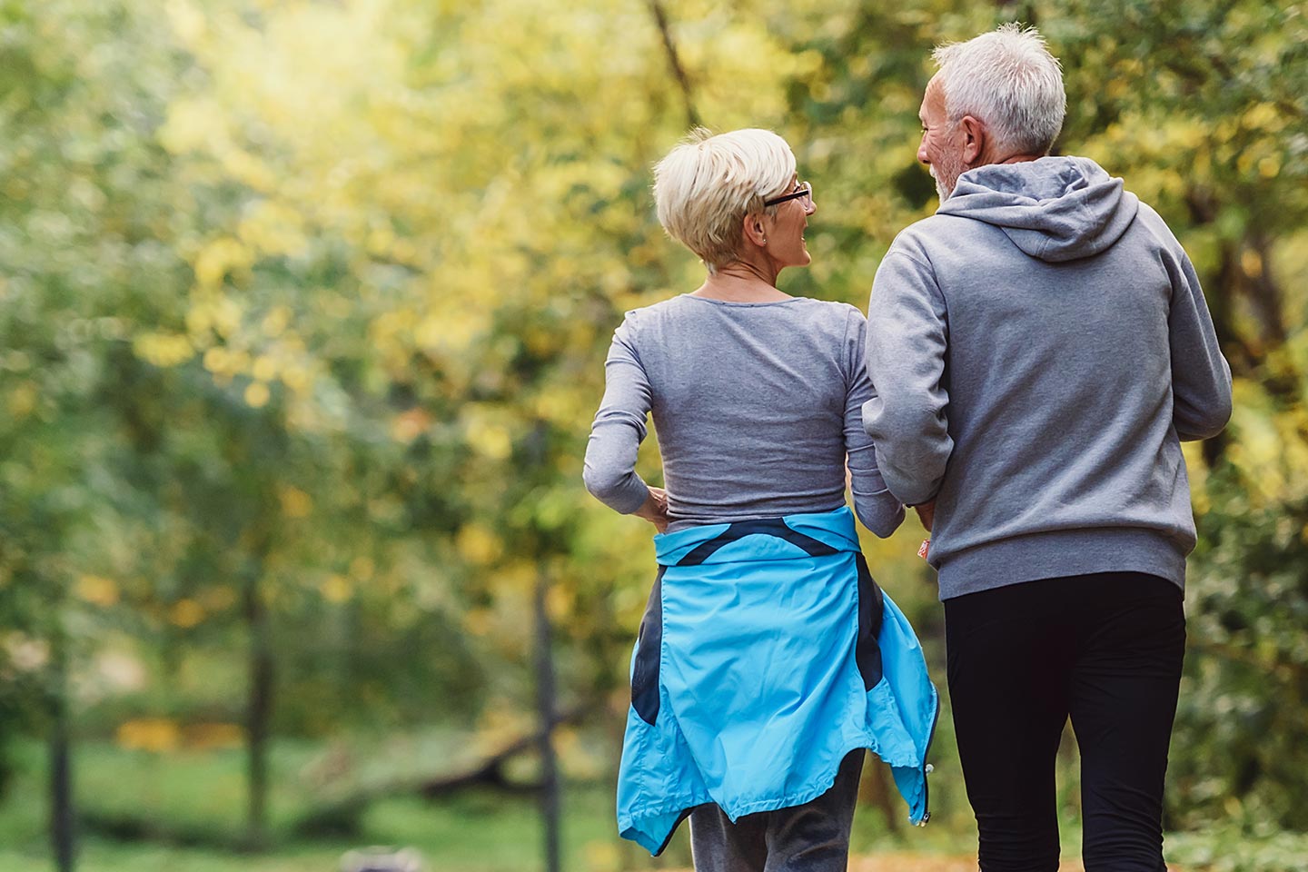 Photo of a fit older couple walking through a park